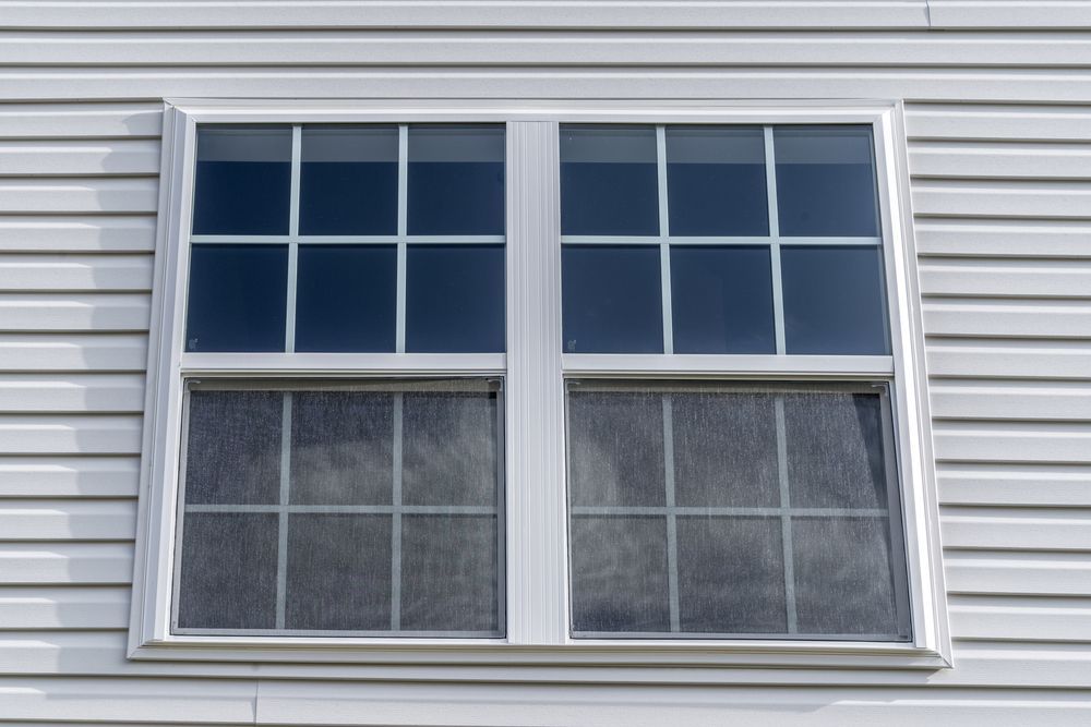 A White Window On The Side Of A House With A Blue Sky Behind It — A & C Classic Window Tinting In Cessnock, NSW