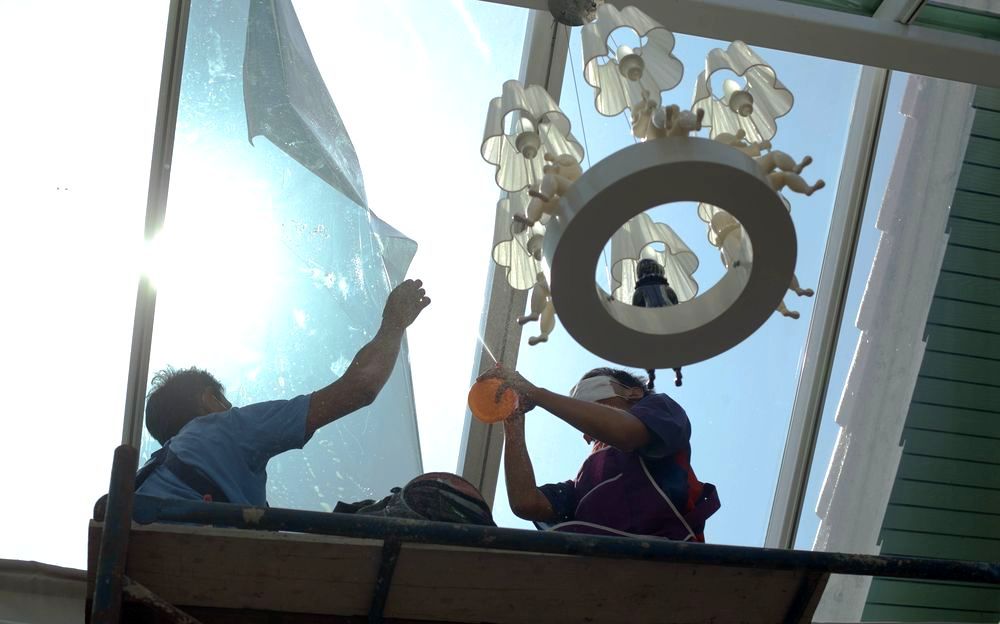Two Men Are Working On A Window — A & C Classic Window Tinting In Cessnock, NSW