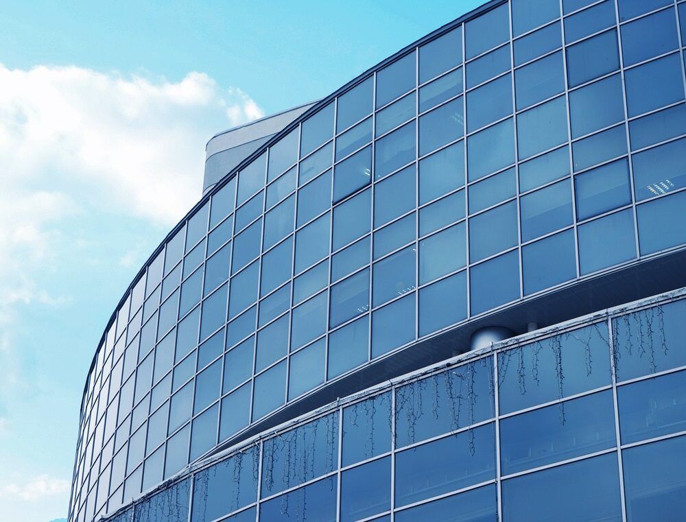 A Building With A Lot Of Windows And A Blue Sky In The Background — A & C Classic Window Tinting In Maitland Vale, NSW