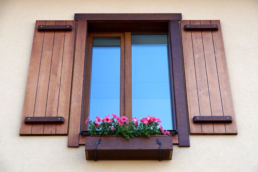 A Window With Wooden Shutters And Flowers In A Window Box — A & C Classic Window Tinting In Wallsend, NSW