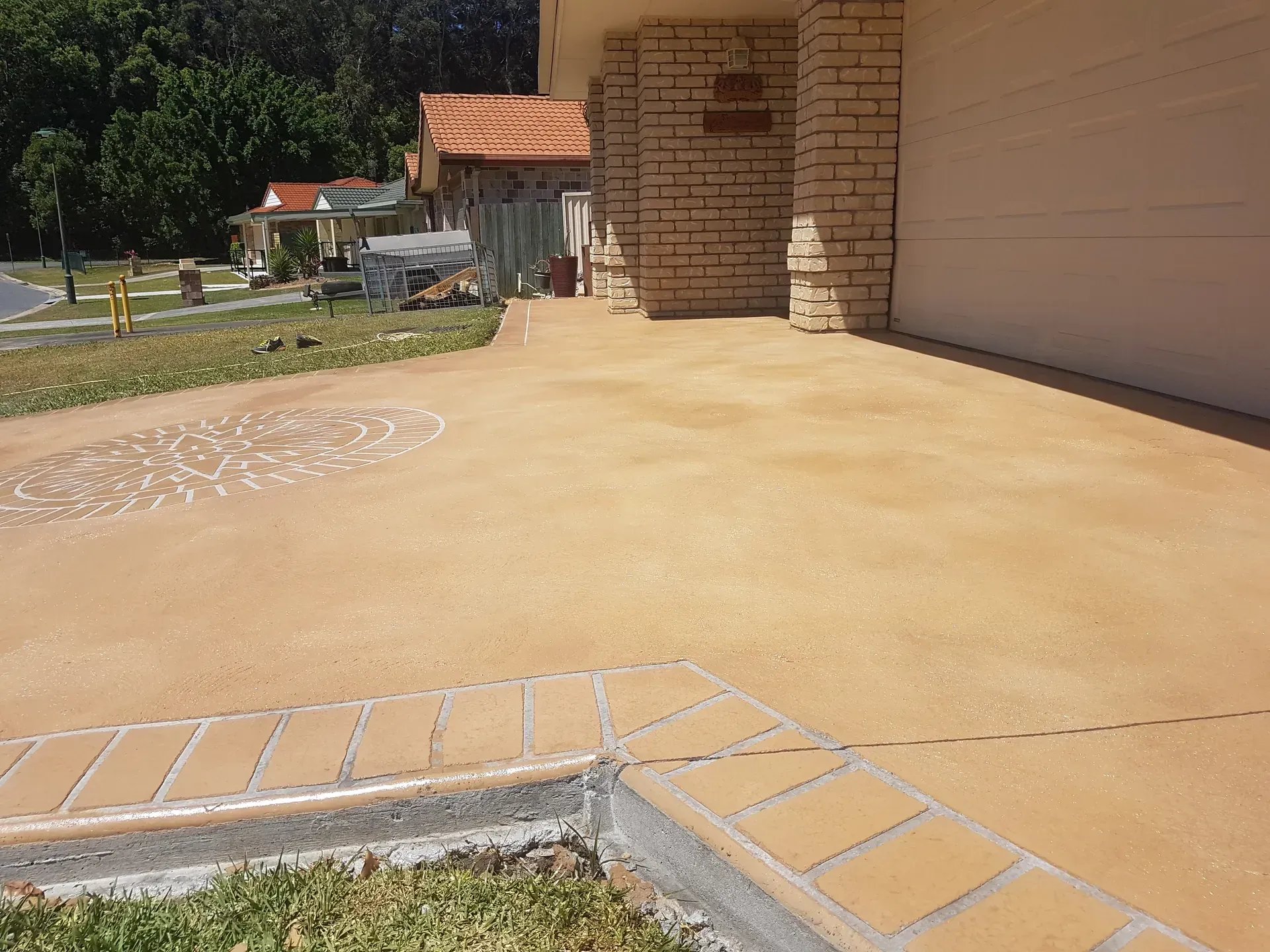 Beige garage with latticework, white door, and paved driveway under a blue sky.