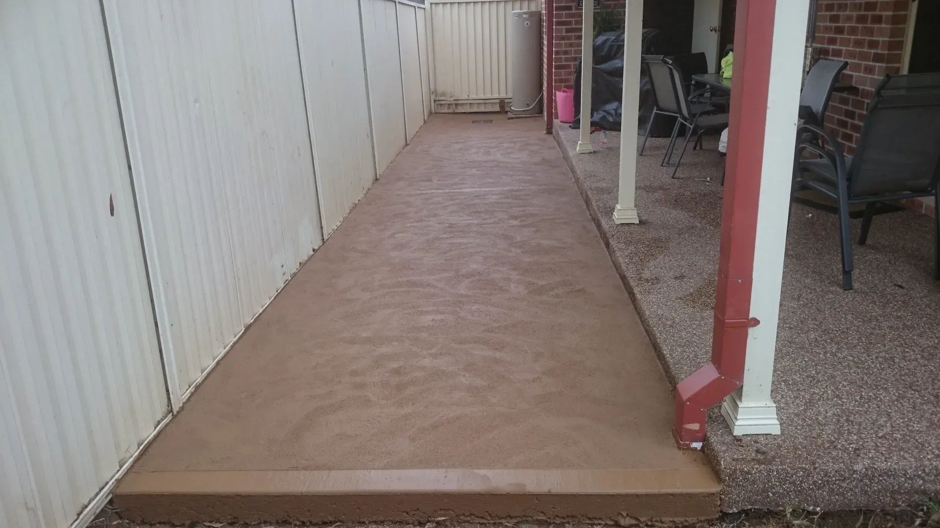 Person Applying Gray Epoxy Flooring With a Trowel, Indoors — Restoradrive in Tweed Heads, NSW