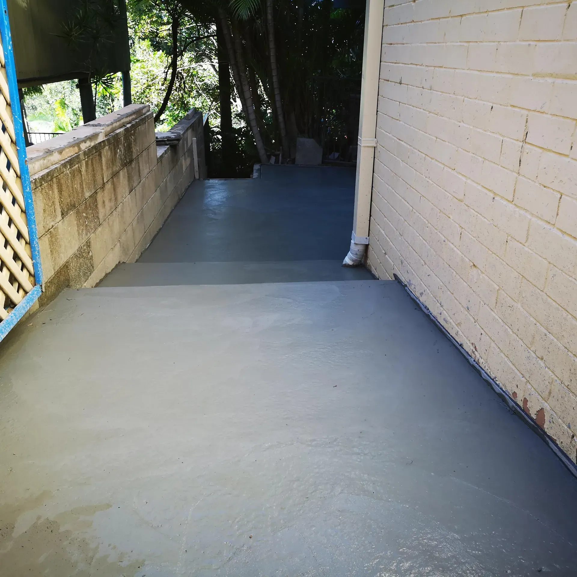 Stamped concrete patio with a metal table, near a building.