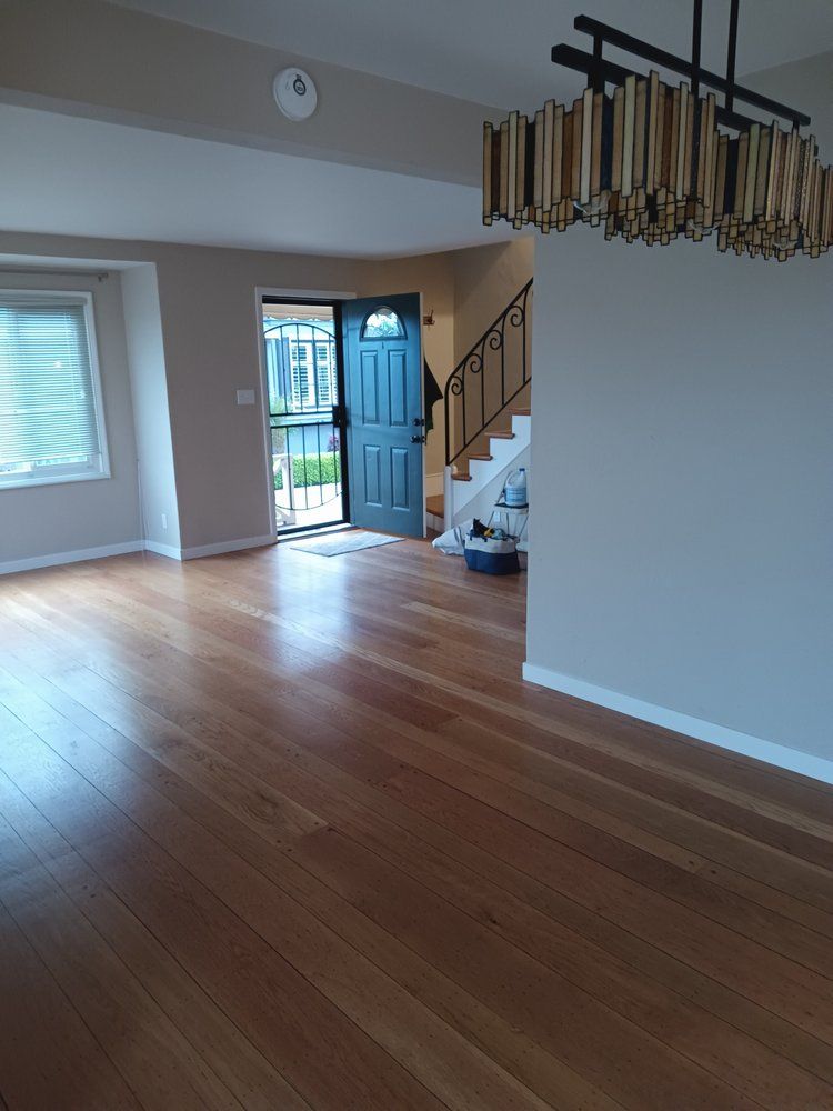 An empty living room with hardwood floors and stairs.