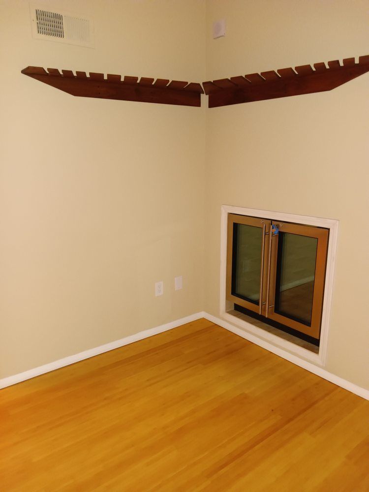 An empty room with hardwood floors and a window