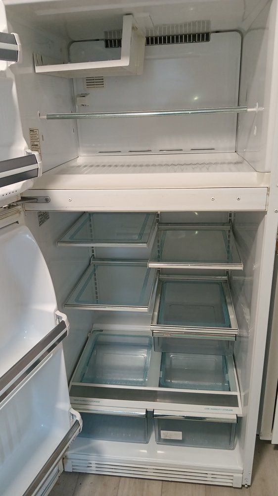 The inside of an empty refrigerator with the door open.