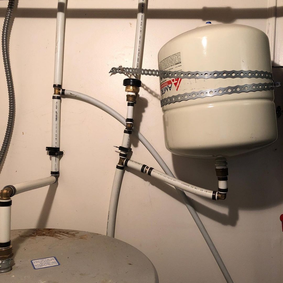 A white water heater is attached to a wall