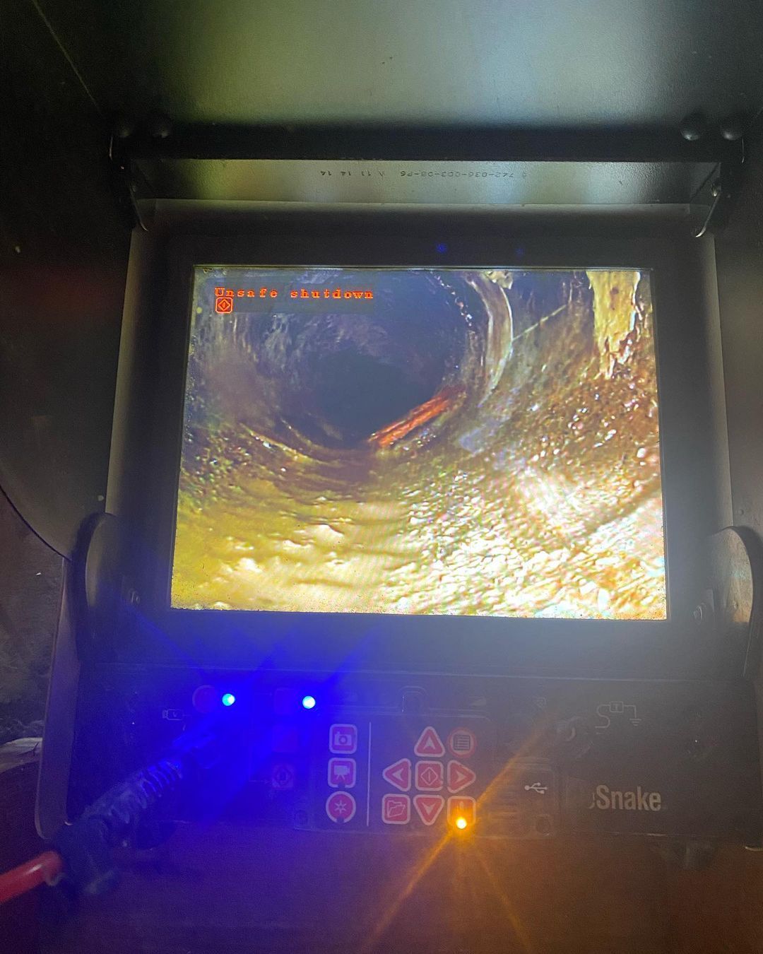 A camera is taking a picture of a hole in a pipe.