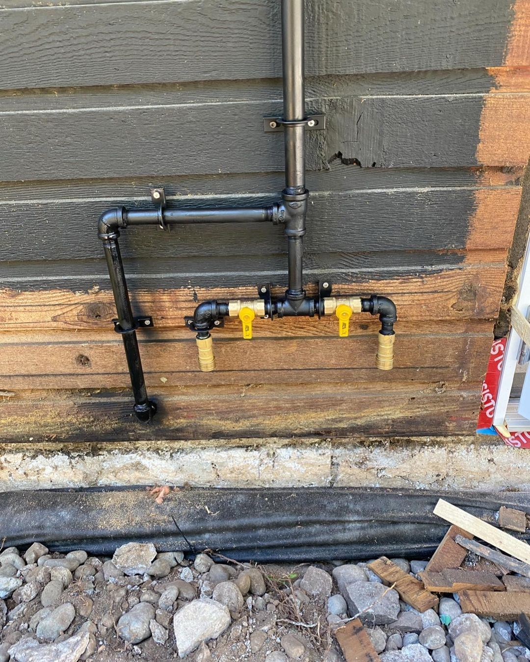 A gas pipe is attached to a wooden wall.