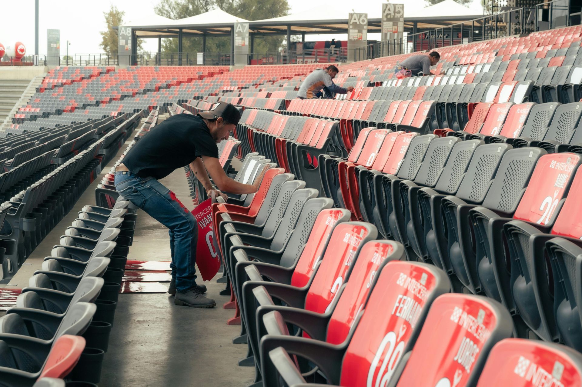 A man is working on a row of empty stadium seats.