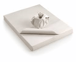 Photo of a pack of white packing paper with an item of china that has been wrapped