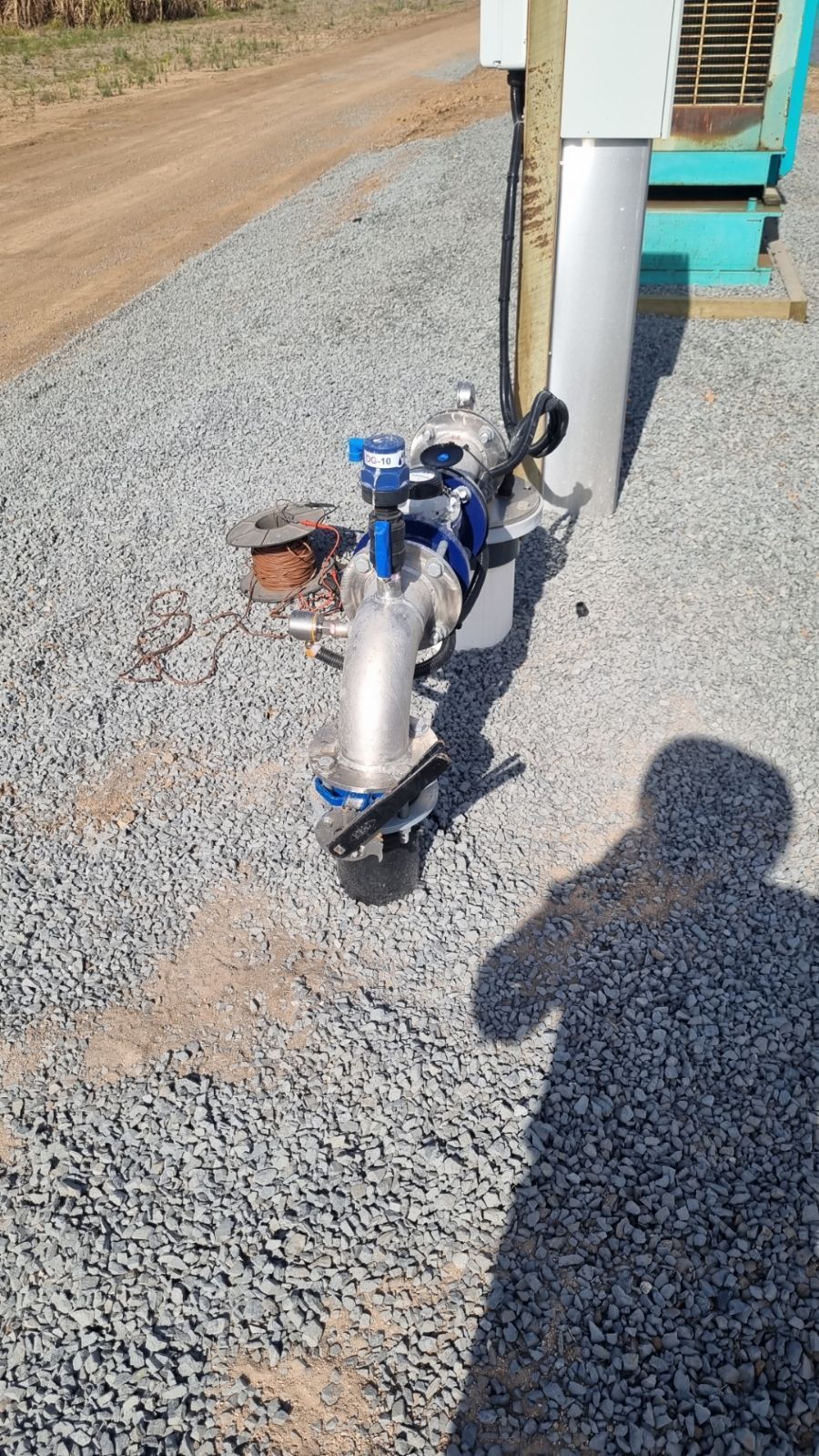 Metal Pipe and Blue Valves on Gravel Ground — Wilson's Drilling in South Kolan, QLD