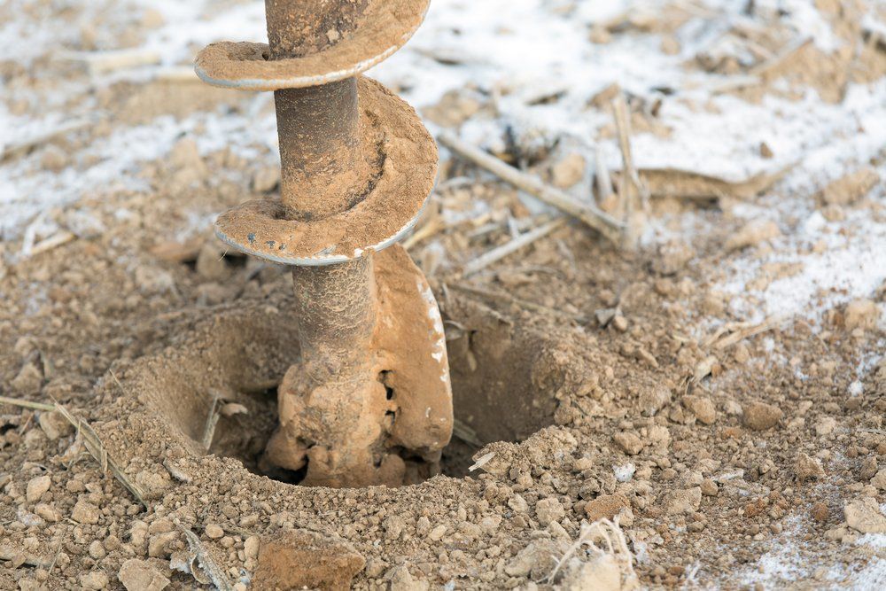 A Drill Bit Boring Into Dry, Tan-colored Soil — Wilson's Drilling in Agnes Water, QLD