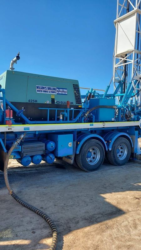 Blue Drilling Rig on a Trailer With Text, Set Against a Clear Sky — Wilson's Drilling in South Kolan, QLD