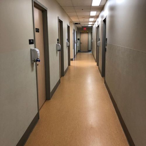 Empty beige hallway with doors and wall-mounted dispensers in a building