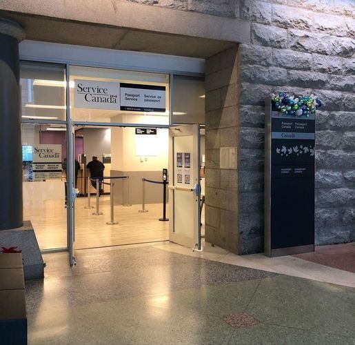 Entrance to a hospital lobby with glass doors, beige walls, and a few people inside