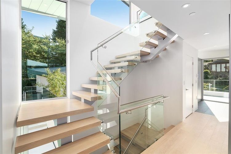 Modern open staircase with glass railings in a bright, contemporary home interior