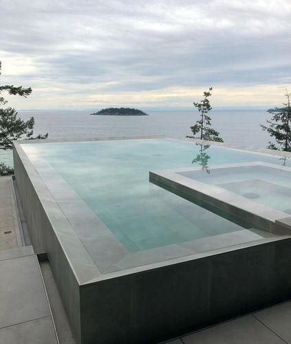 Infinity pool overlooking a calm sea with a small island in the distance