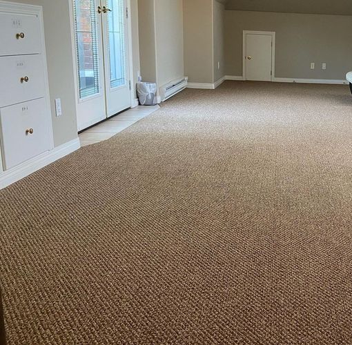 Empty beige carpeted room with French doors, a white closet, and a small wall door