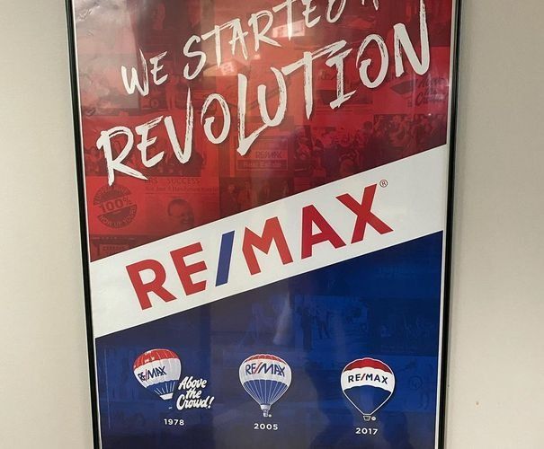 RE/MAX poster with “We Started Revolution” slogan in red, white, and blue