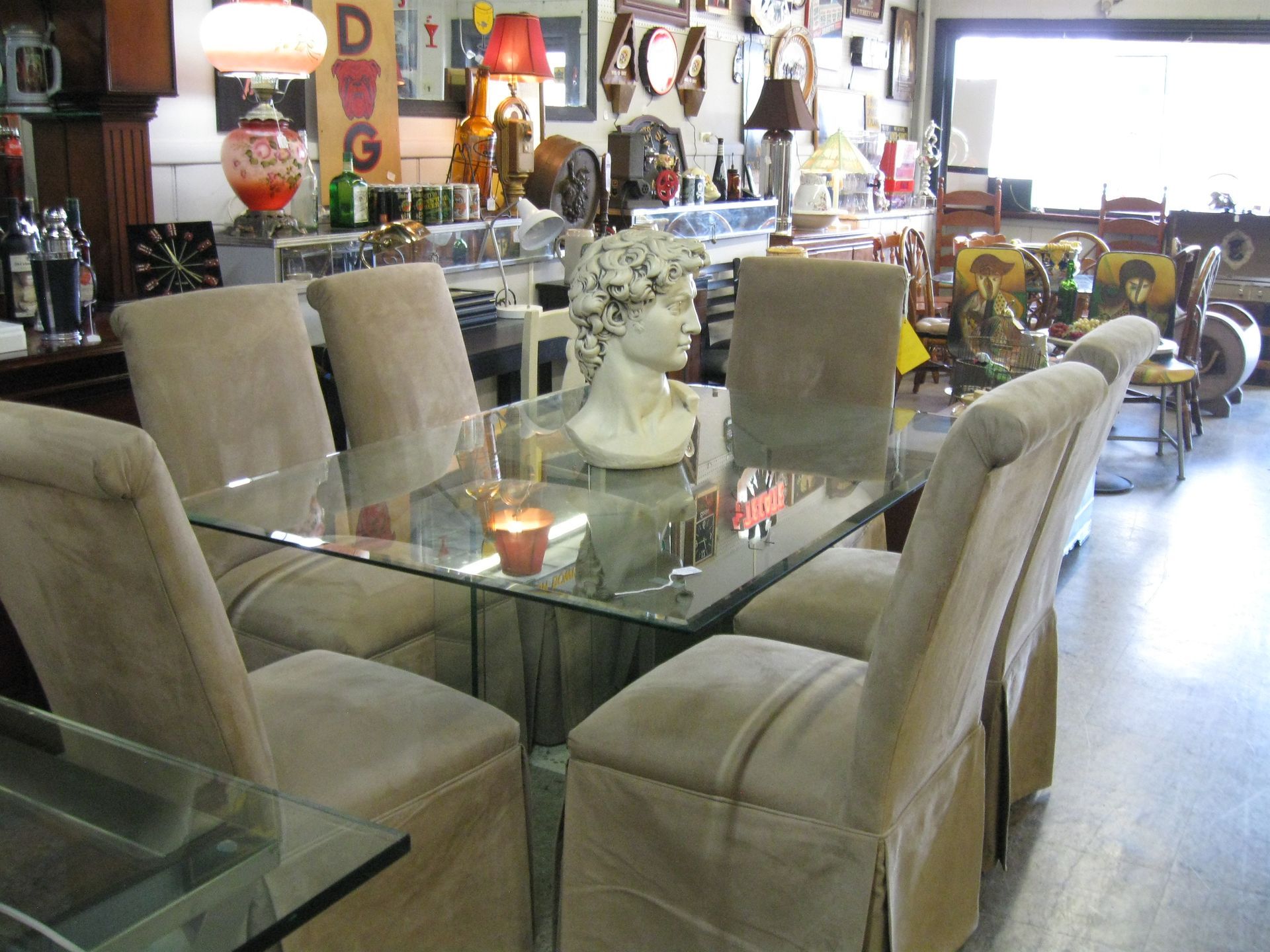 Glass dining table with beige chairs in a furniture store showroom
