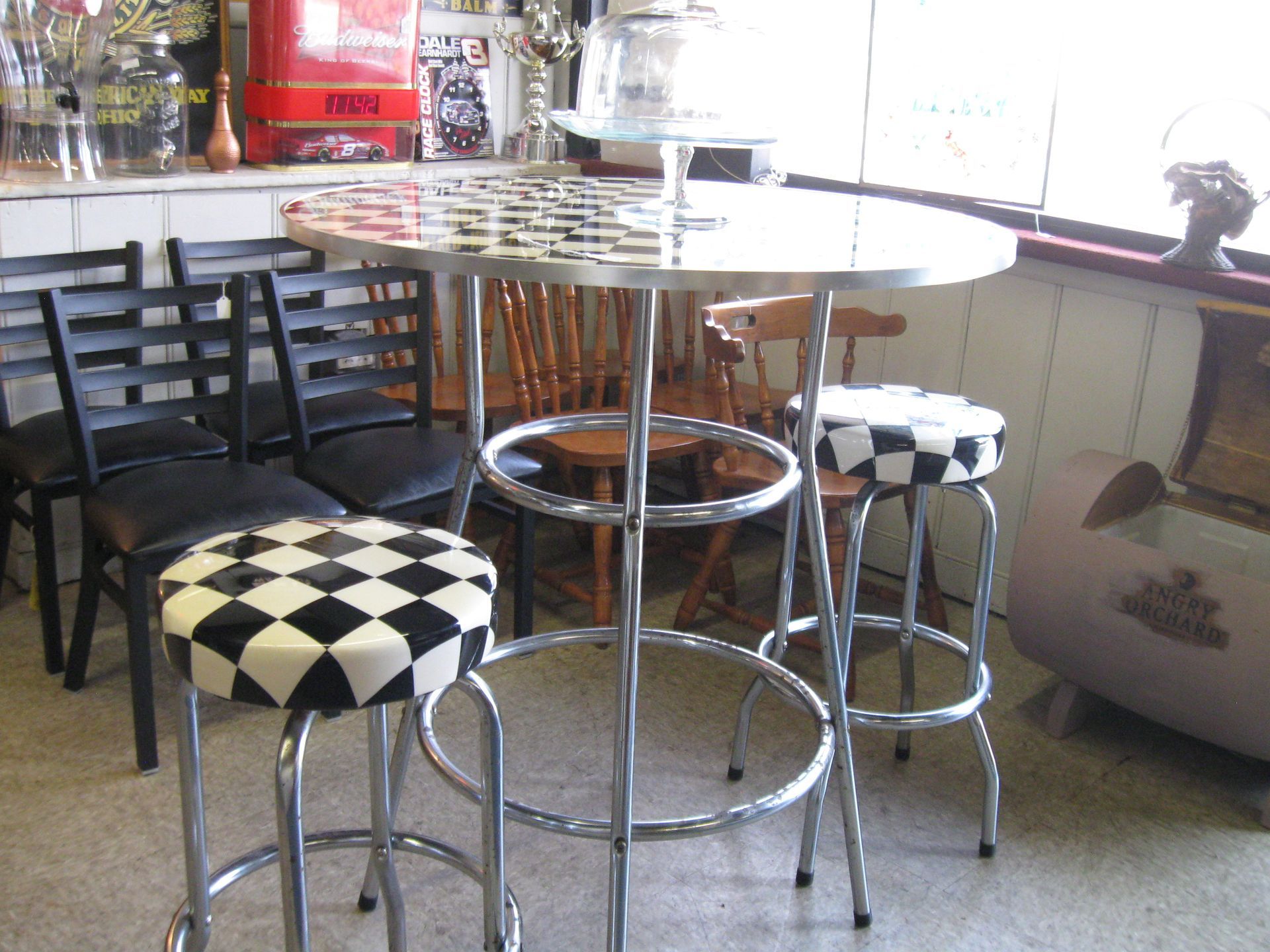 Round table with black-and-white stools in a diner corner.