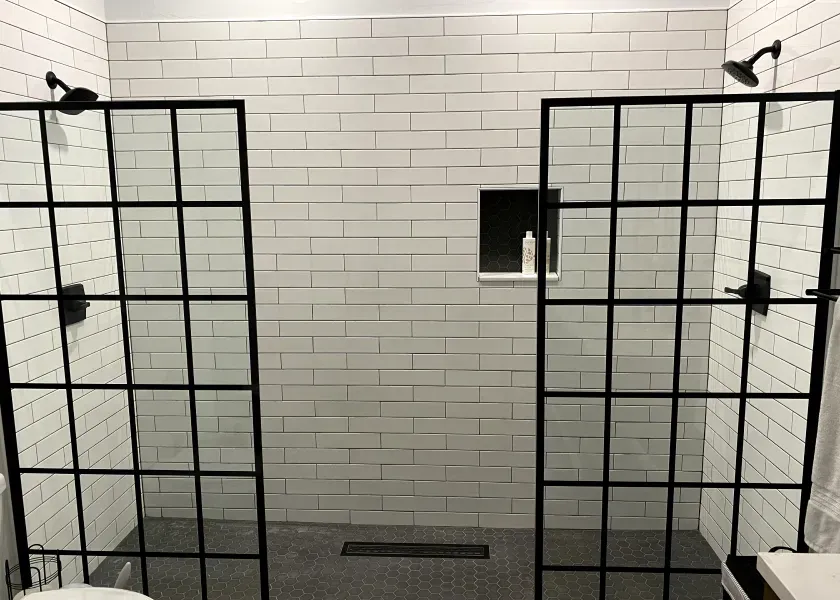 A bathroom with two walk in showers and a toilet.