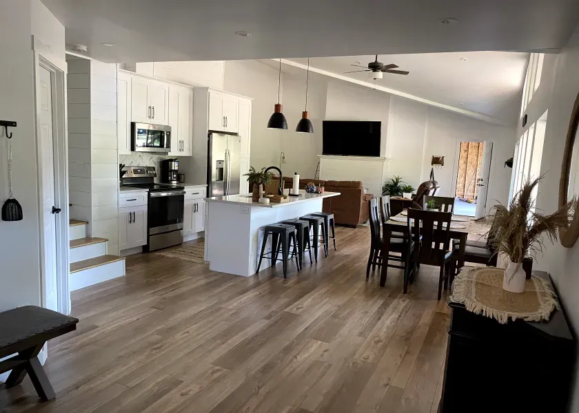 A large living room with a kitchen , dining room , and stairs.