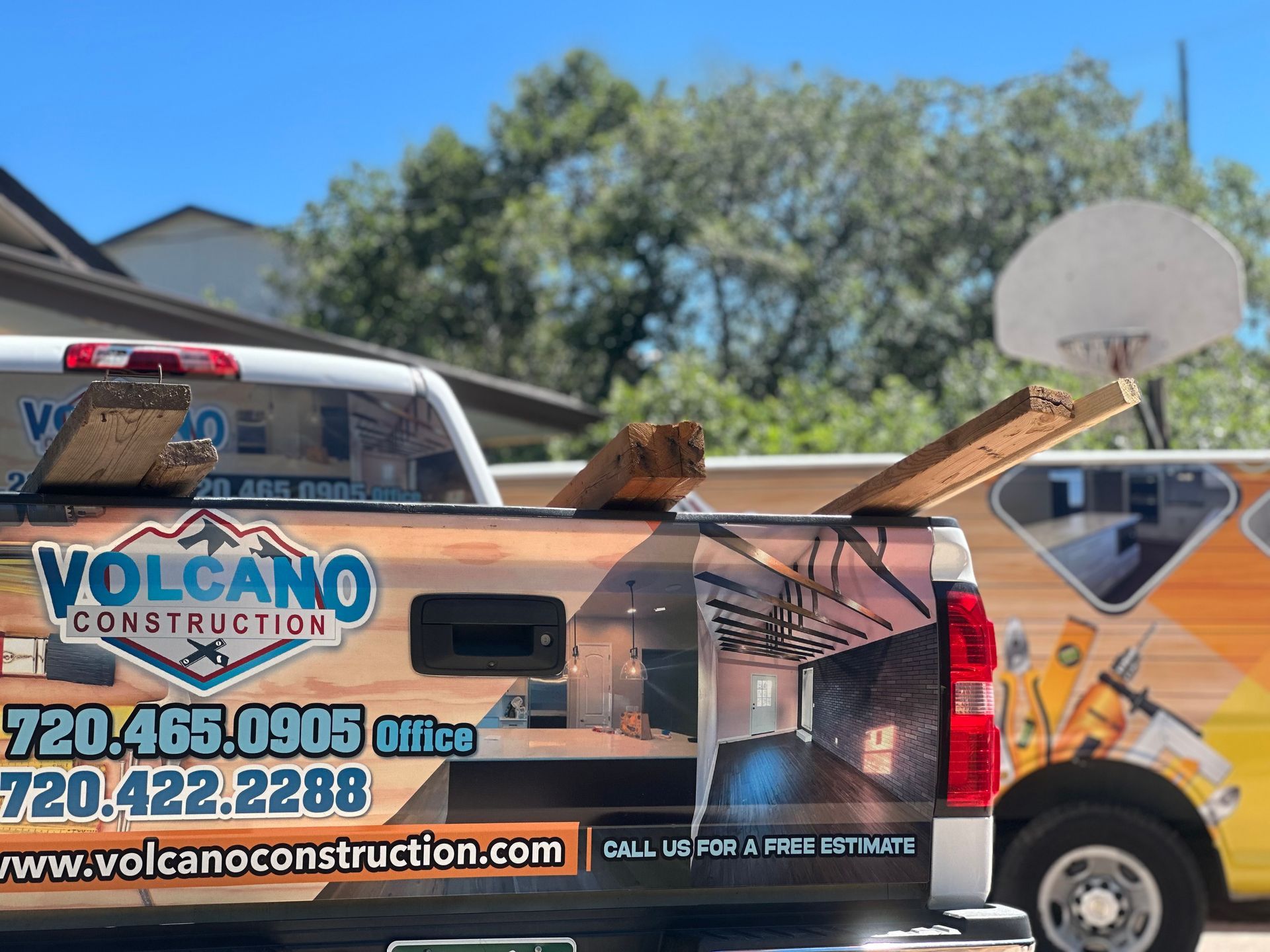A volcano construction truck is parked in front of a house.