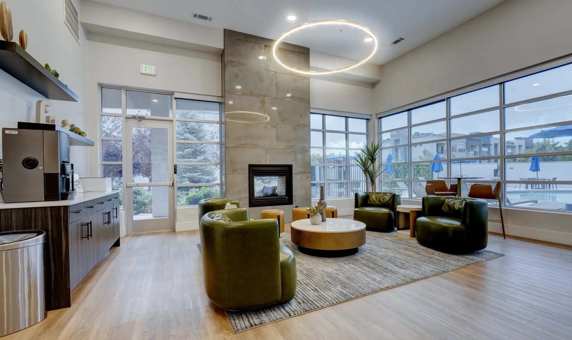 Modern lounge area with plush seating, fireplace, and large windows overlooking the pool.