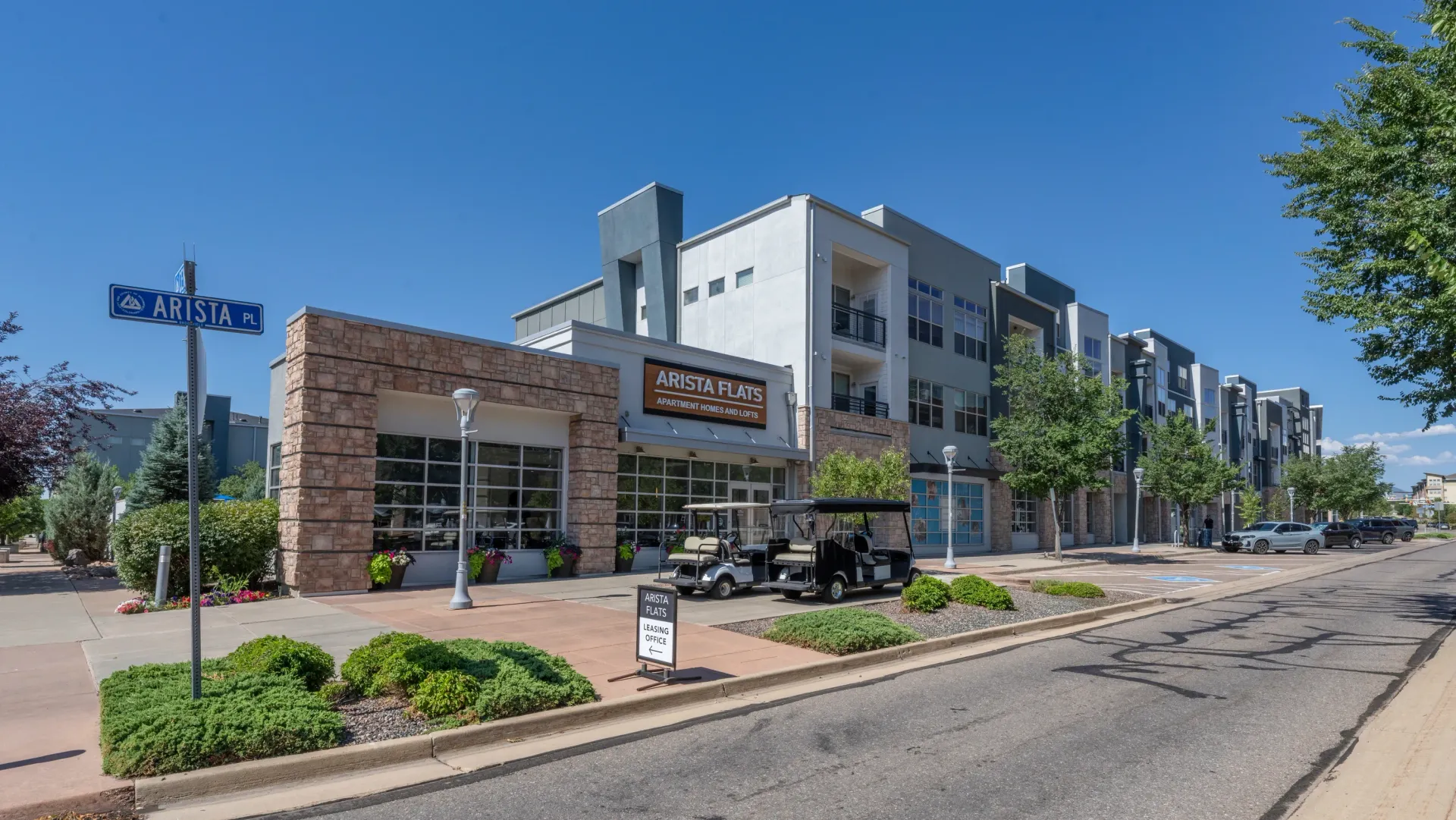 Arista Flats apartment homes and lofts building exterior with signage and street view.