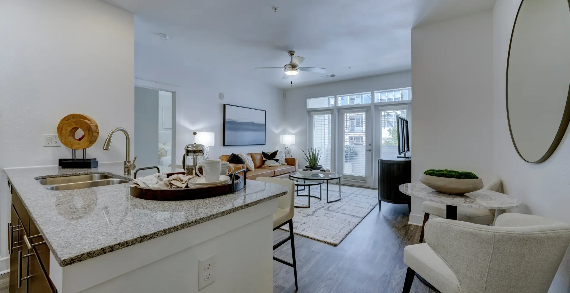 Kitchen and living room in a modern apartment with sleek finishes and comfortable furniture.
