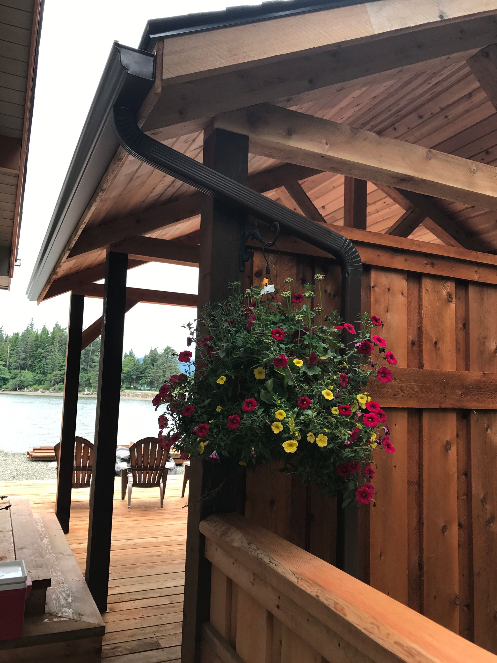 Wooden porch with hanging flower basket by a lakeside cabin
