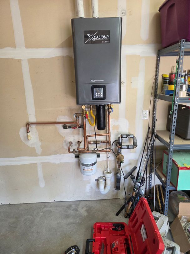 A wall-mounted water heater above a utility sink, with two water fountains to the right.