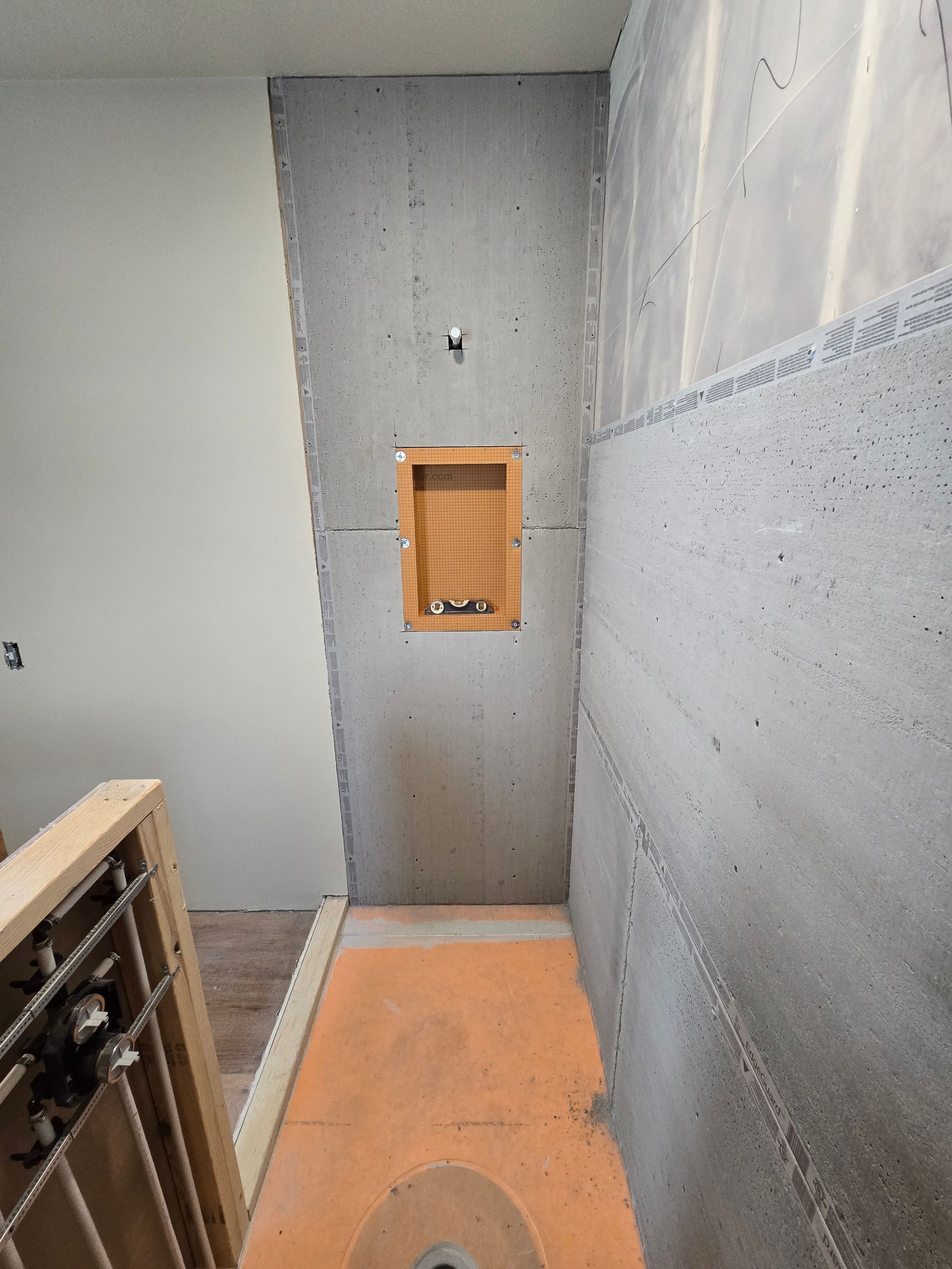 Stairwell landing with gray concrete walls and an orange vent on the far wall.