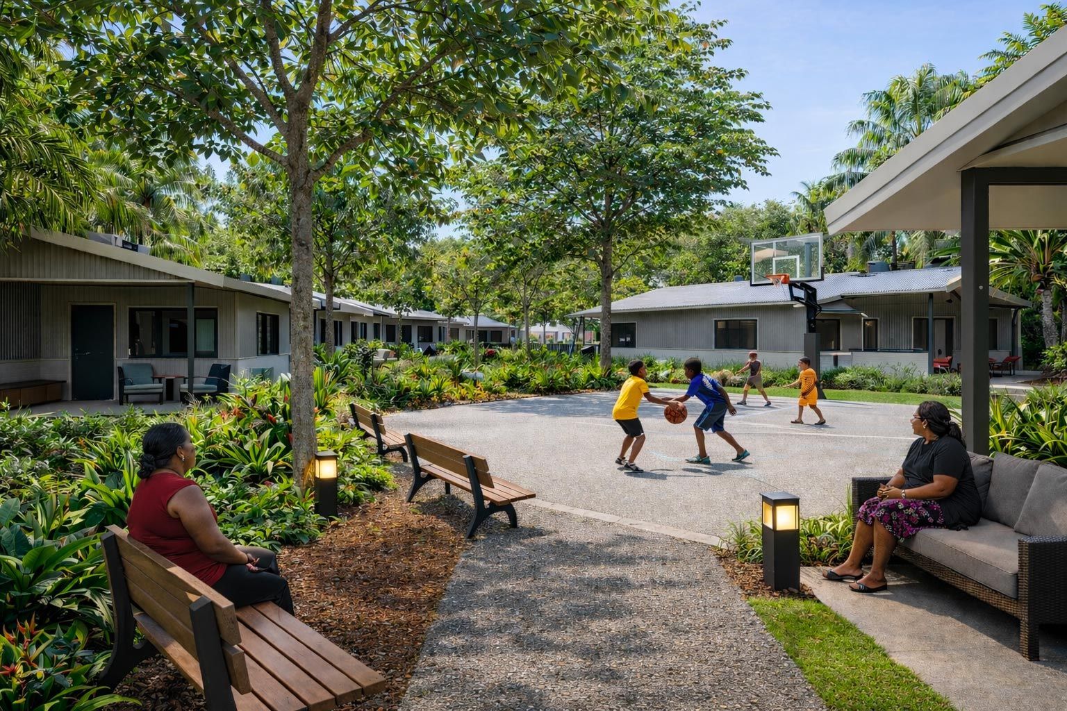 Children play basketball on a gravel court surrounded by trees and residential buildings, with people resting on benches.