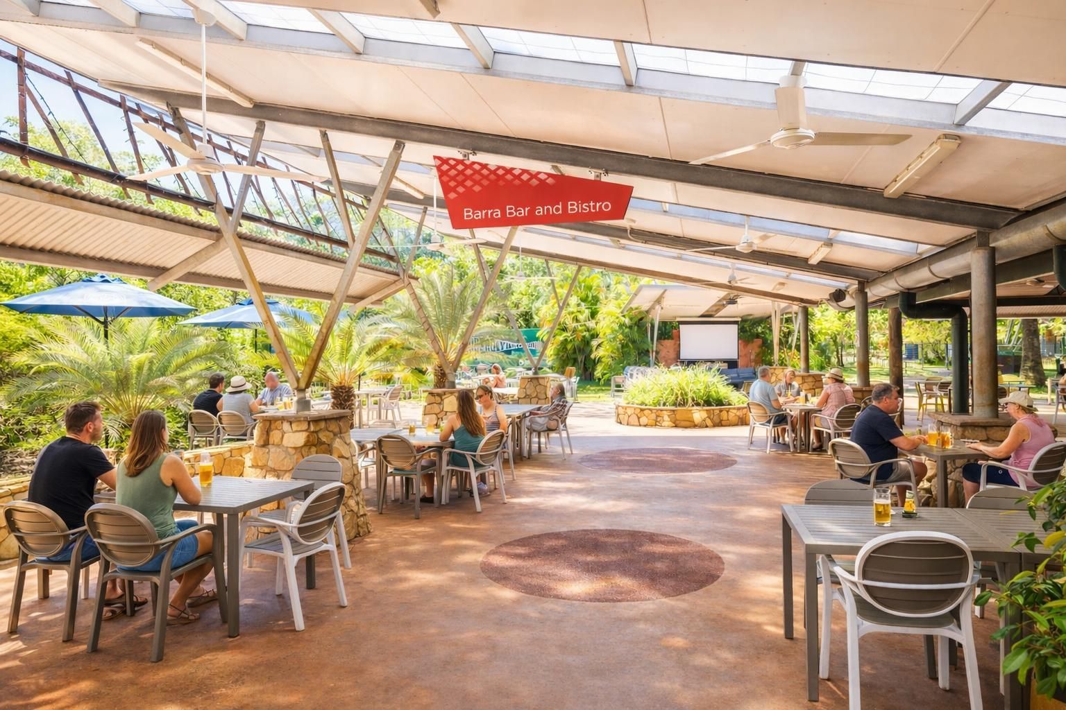 A white building with wooden privacy screens under a corrugated metal awning, surrounded by green shrubs.