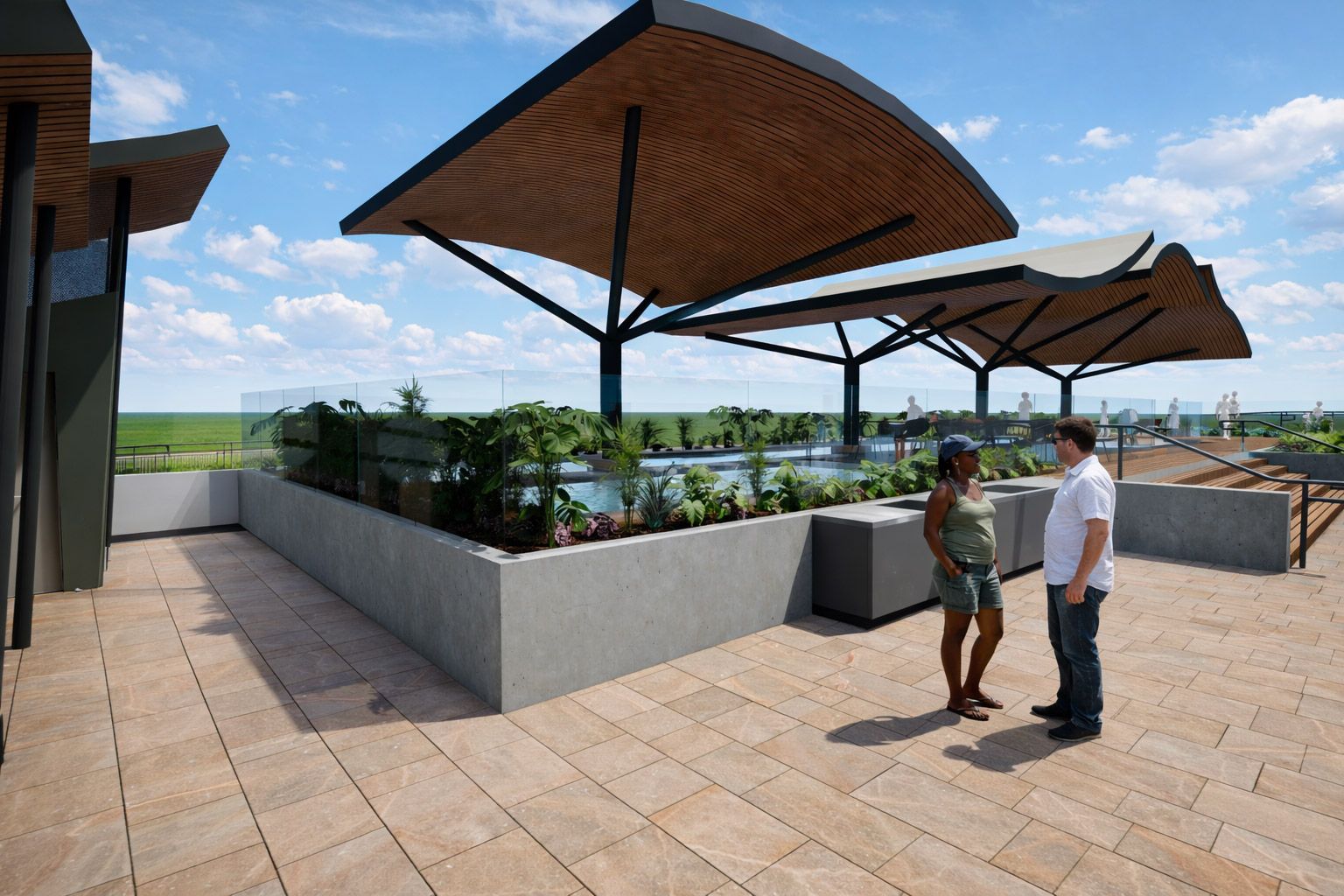 Two people standing on a rooftop terrace with landscaped planters and shaded seating areas under large, modern canopies.