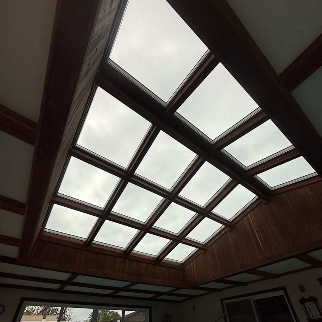 Wood-paneled ceiling with large rectangular skylights letting in daylight indoors