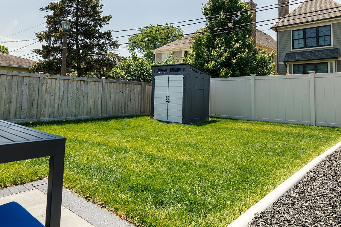 There is a shed in the backyard of a house.