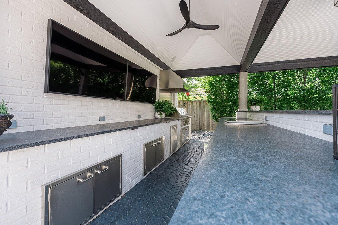 A rendering of an outdoor kitchen with a ceiling fan.