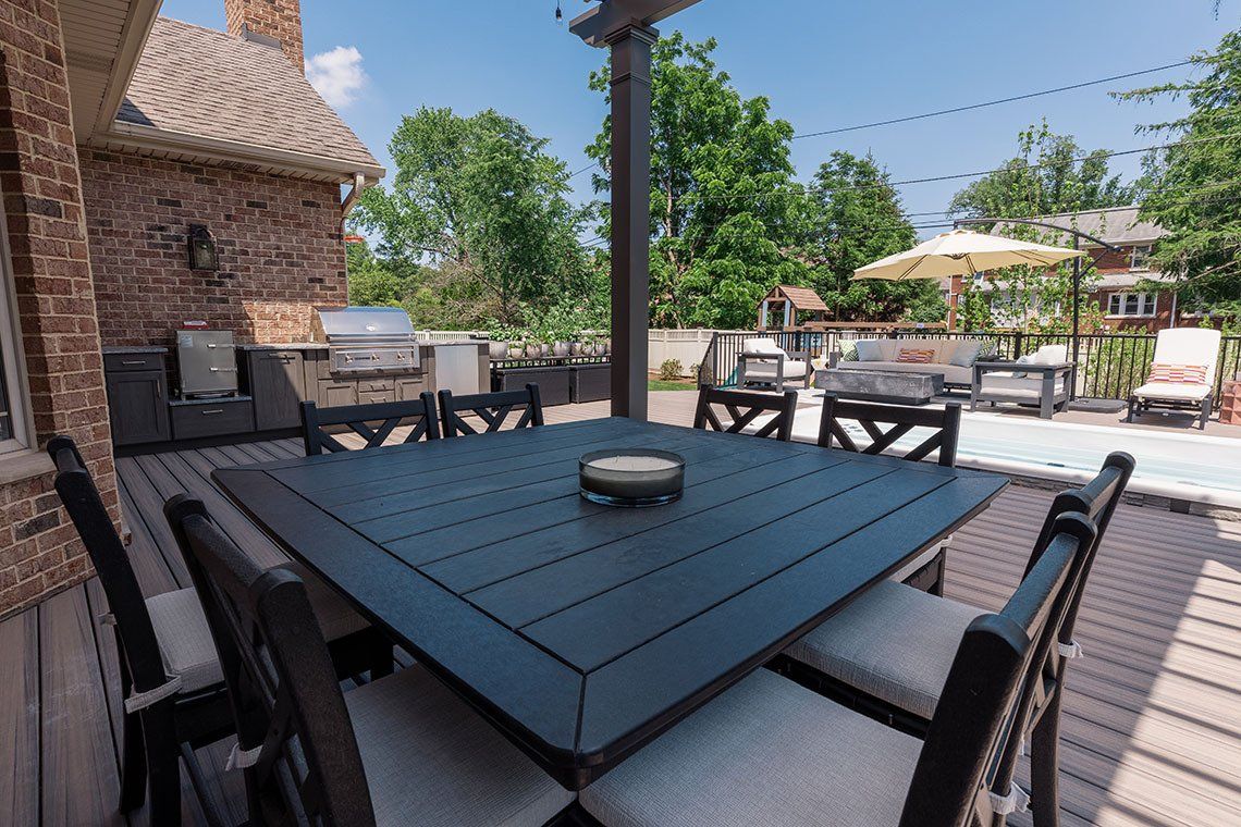 A patio with a table and chairs and a swimming pool.