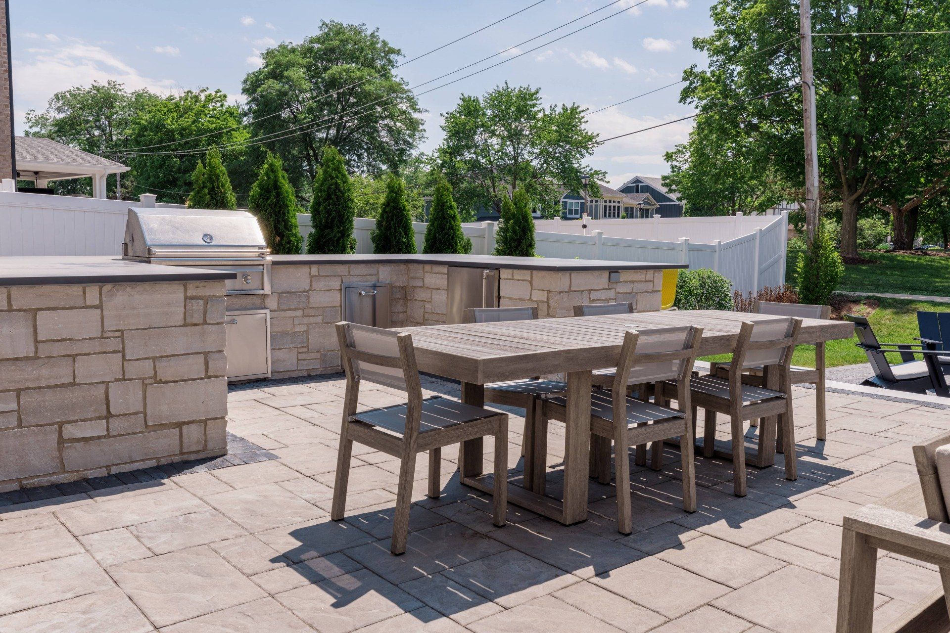 A patio with a table and chairs and a grill.
