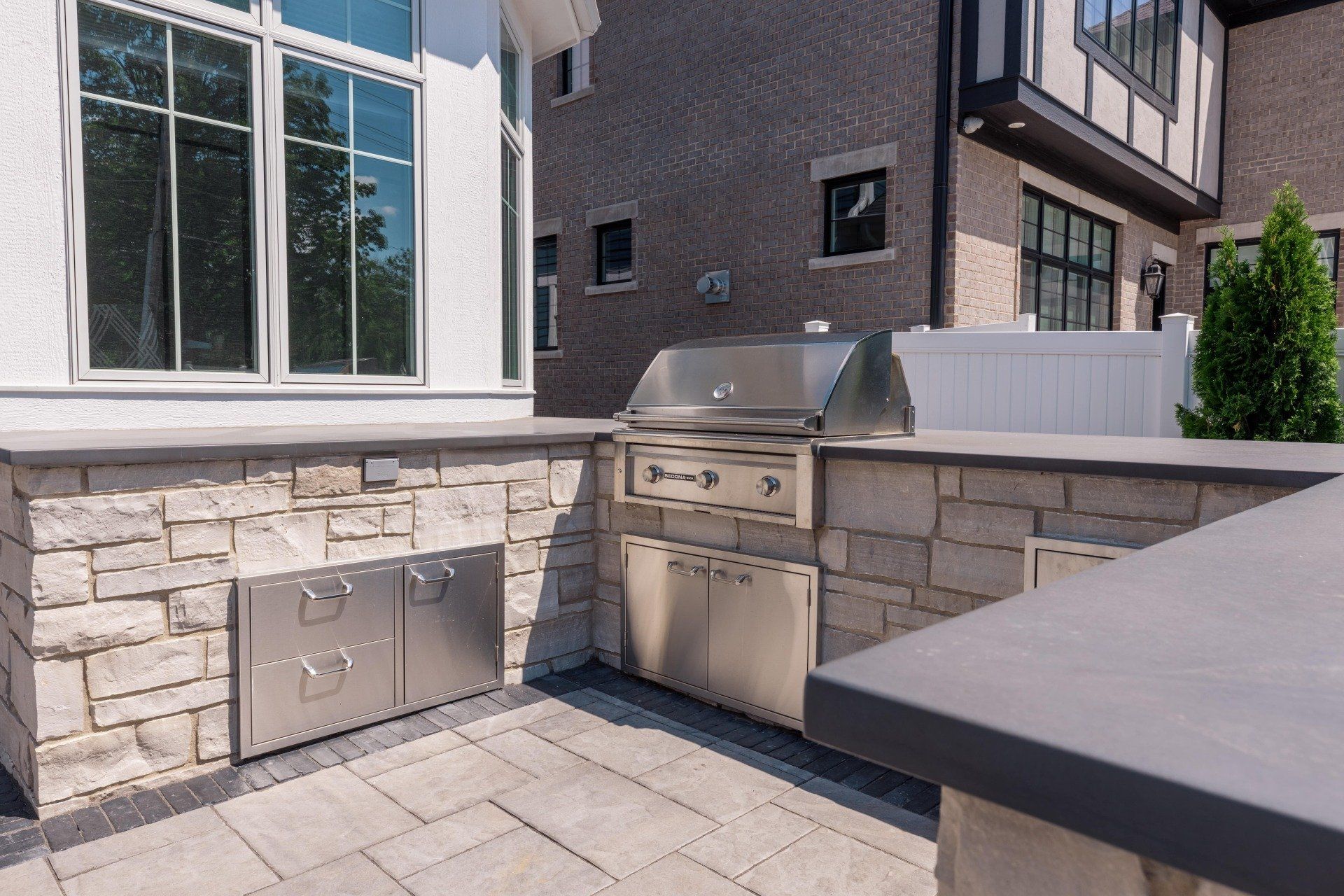 There is a grill in the backyard of a house.