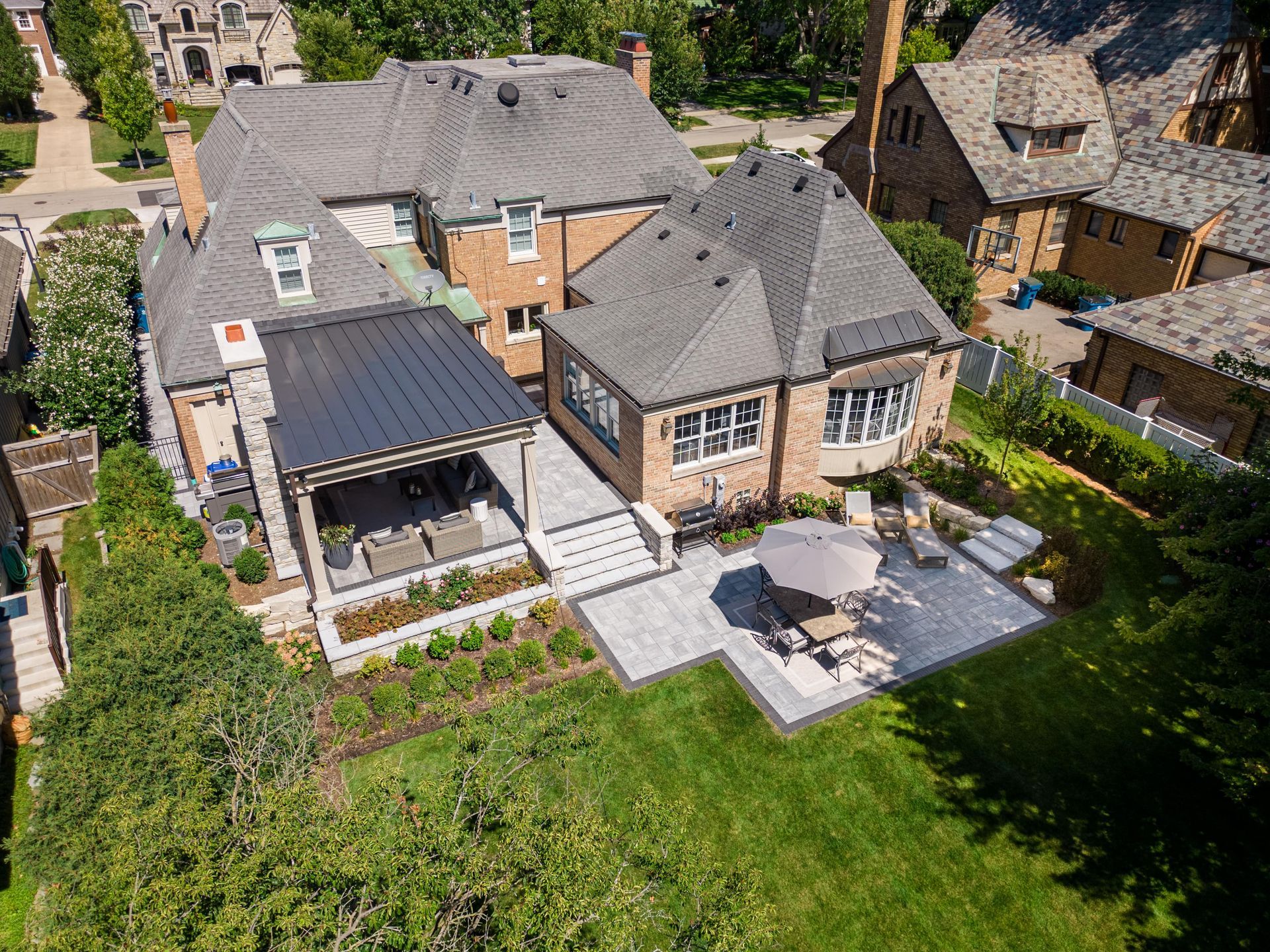 An aerial view of a large house with a patio in front of it.