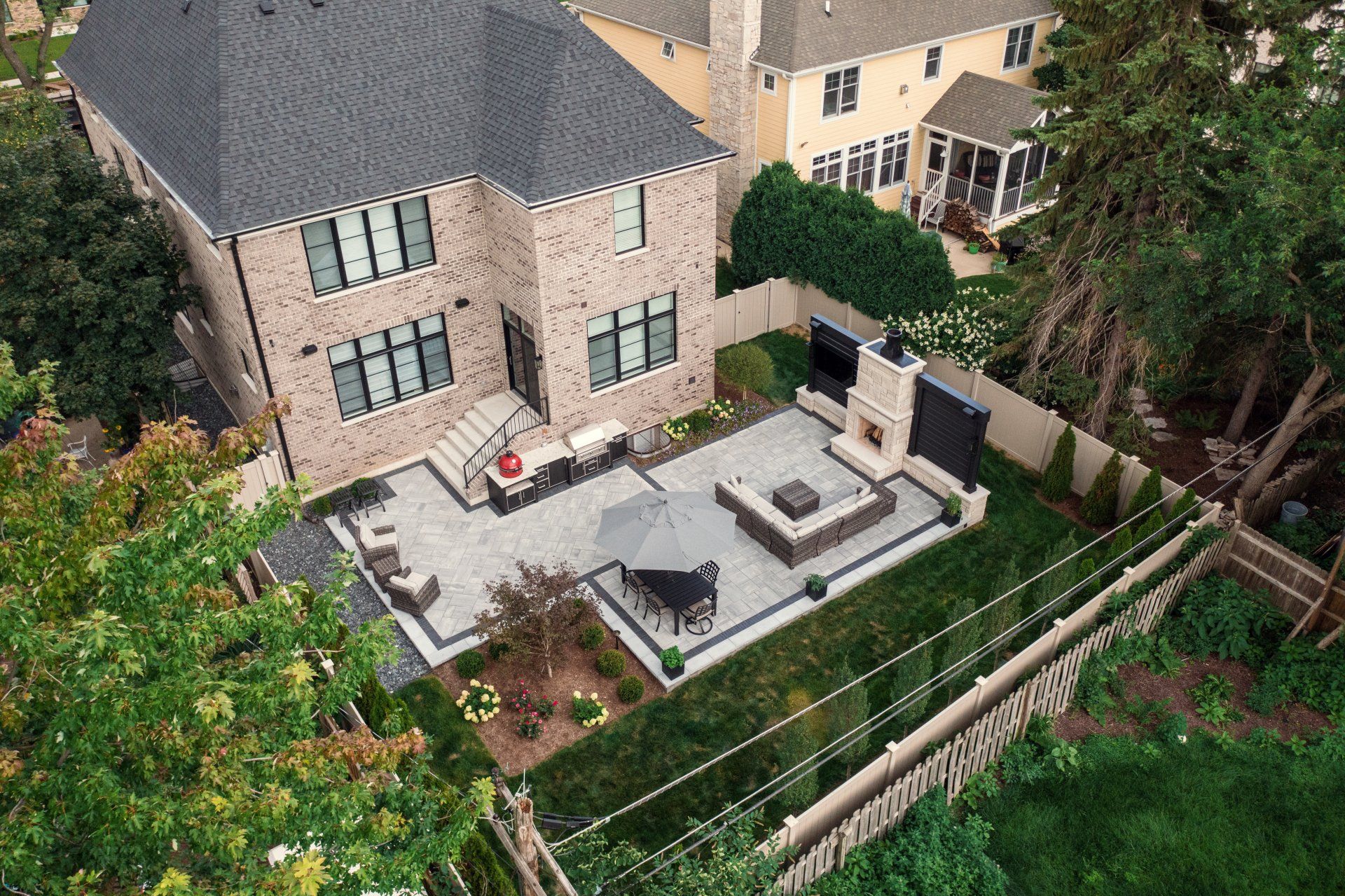 An aerial view of a house with a patio and a fire pit.
