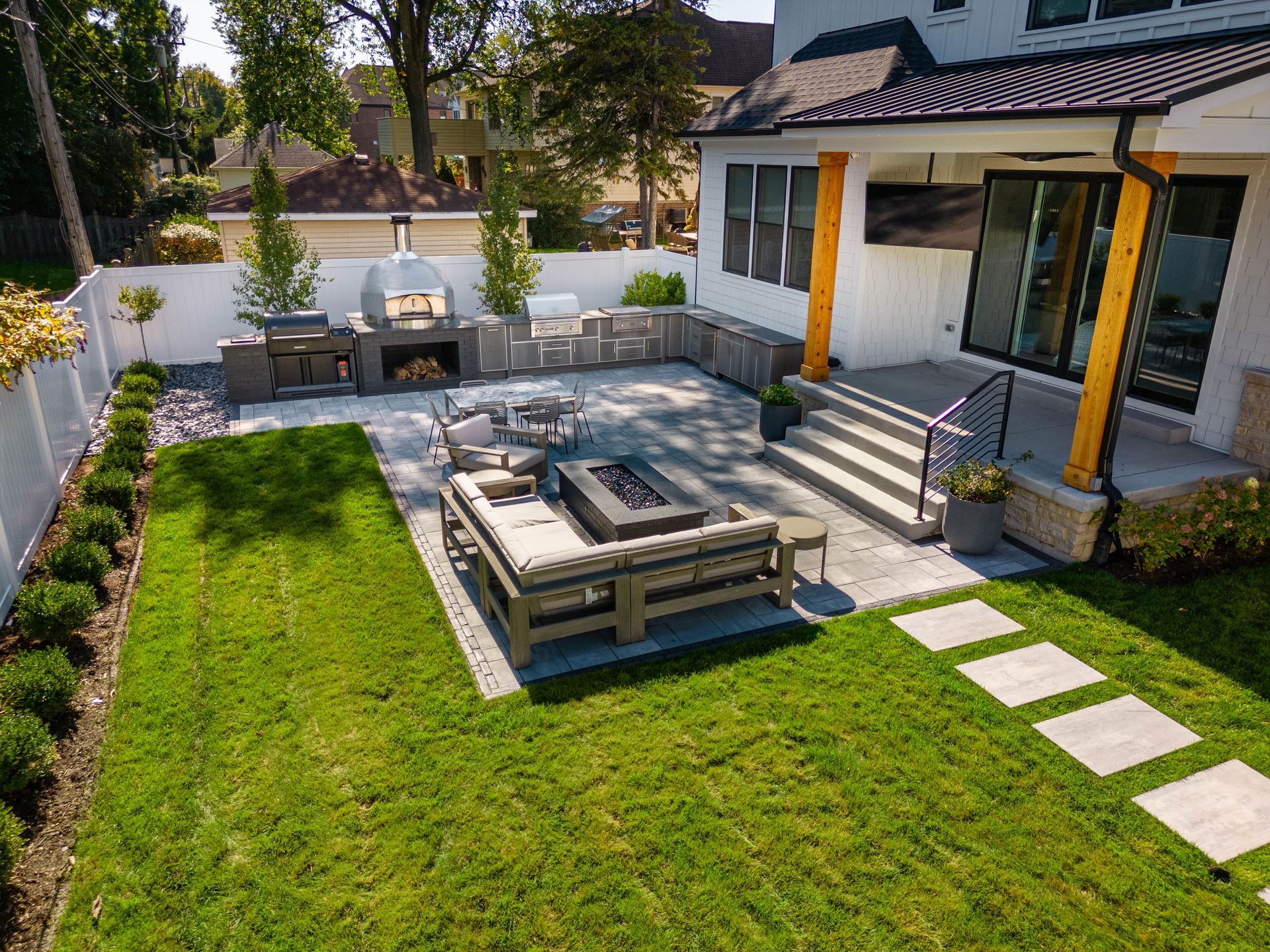 An aerial view of a backyard with a fire pit and patio furniture.