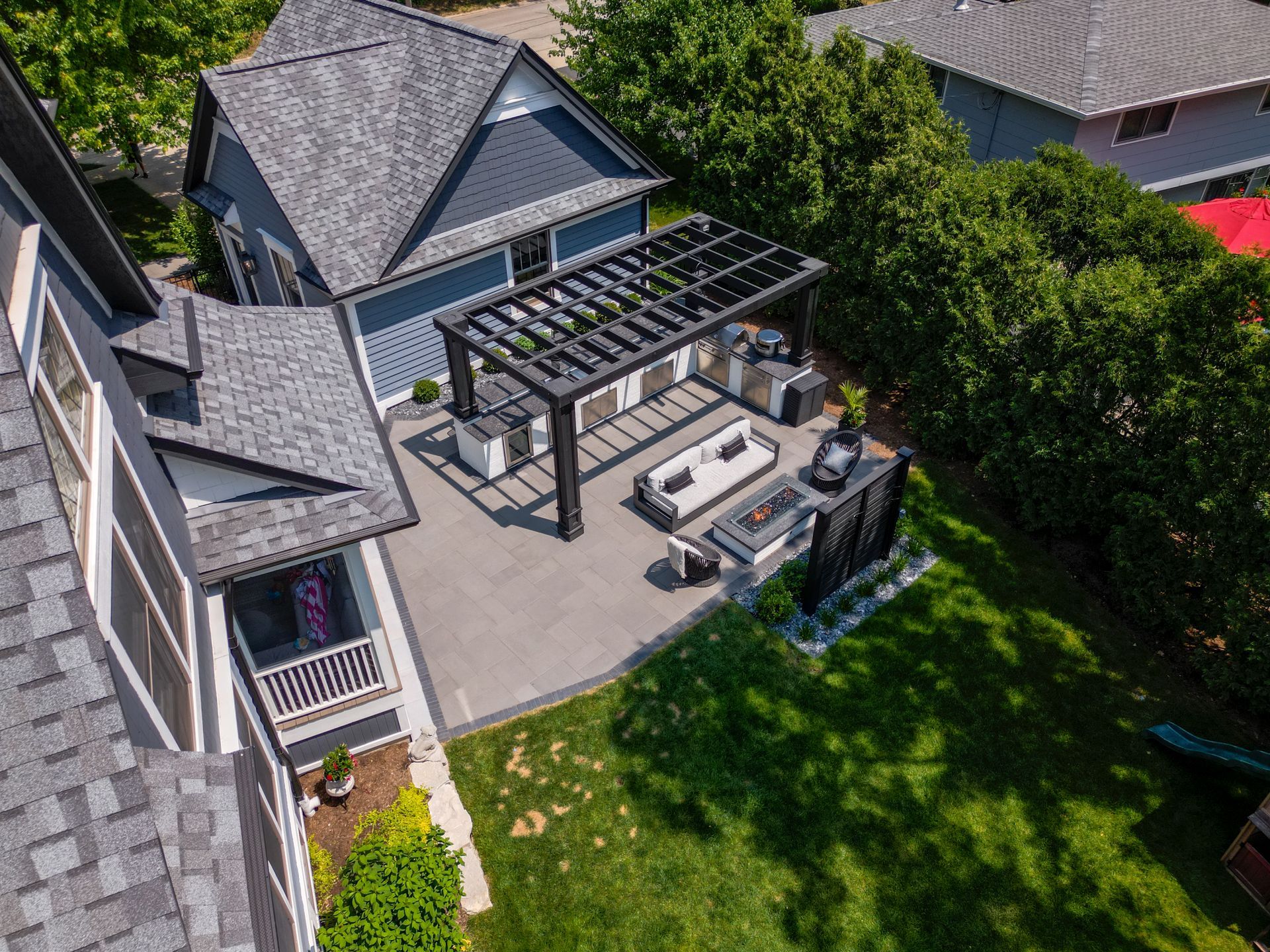 An aerial view of a house with a pergola in the backyard.