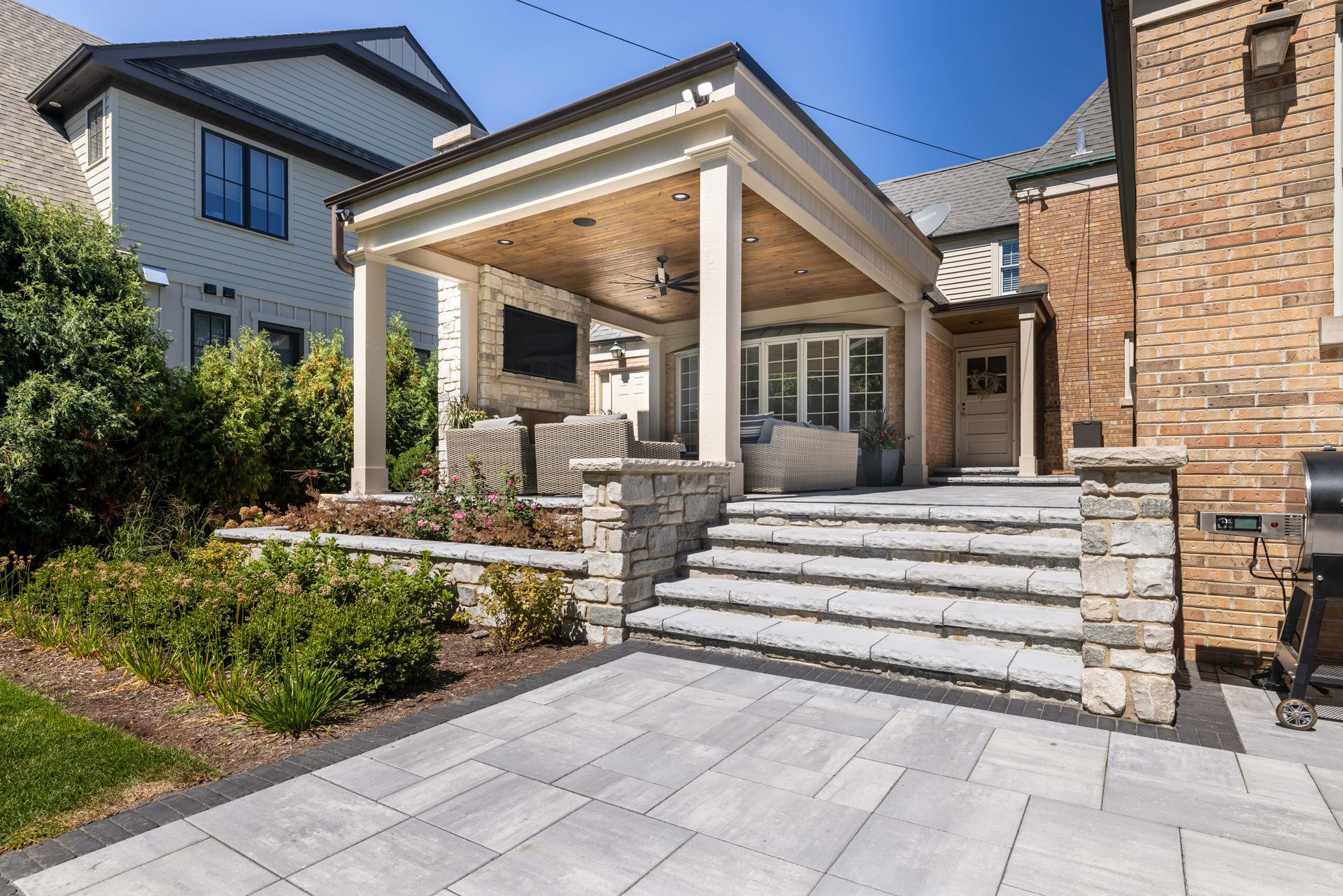 A large brick house with a porch and stairs leading up to it.