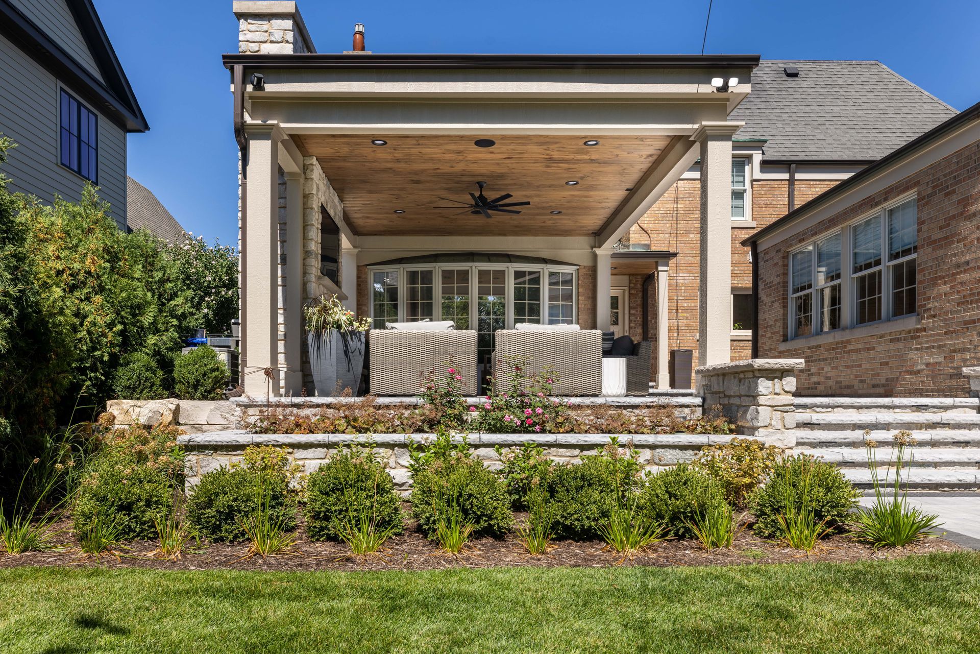 The back of a house with a covered porch and stairs leading up to it.